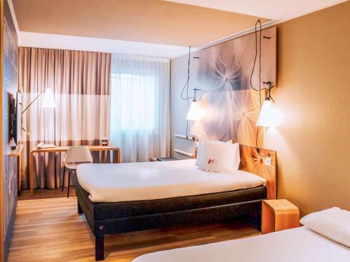 Pokój hotelowy z 2 łóżkami i biurkiem w obiekcie ibis Hotel Frankfurt Airport w mieście Kelsterbach