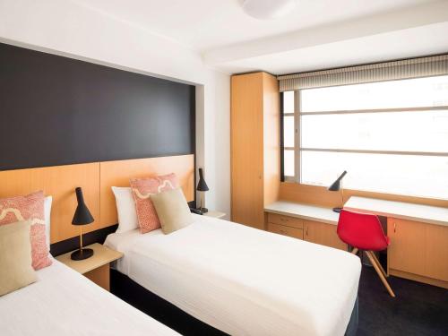 una camera d'albergo con due letti e una finestra di ibis Sydney World Square a Sydney