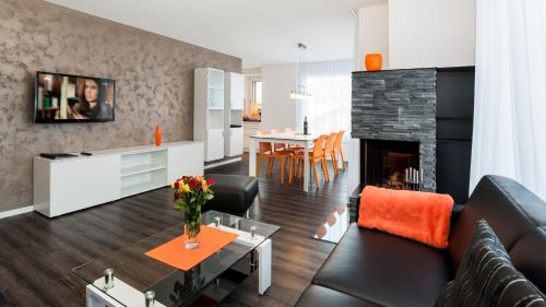 a living room with a couch and a fireplace at Apartments Auriga in Saas-Fee