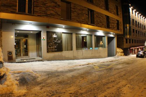a snow covered street in front of a building at Hotel Cubil in Pas de la Casa