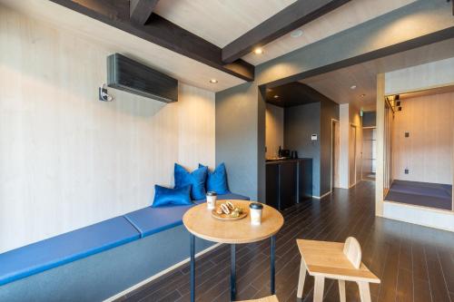 een woonkamer met een blauwe bank en een tafel bij TABITABI STAY KAWAMA in Kyoto