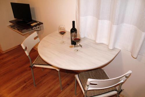 a table with two glasses and a bottle of wine at Apartment Studio Fuart in Štinjan
