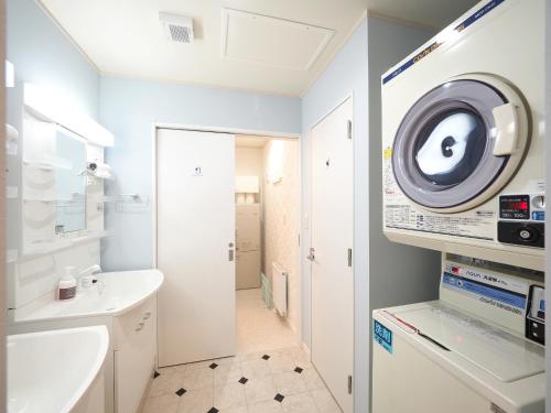 a bathroom with a sink and a washing machine at Family Tree Guest House in Sapporo