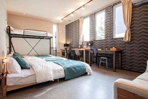 a bedroom with a bunk bed and a desk at UCHI Living Stay TOYOHIRA in Sapporo