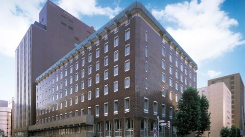 a tall brown building in a city at Sapporo Grand Hotel in Sapporo