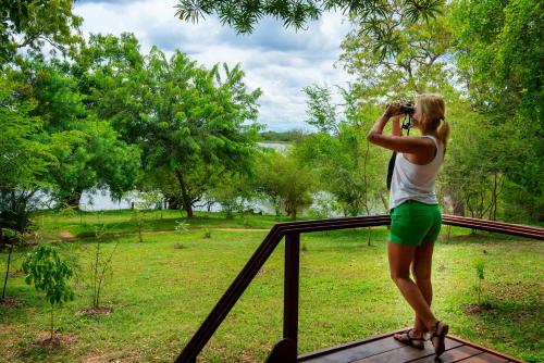 a woman taking a picture of a park with her camera at Kulu Safaris - All Inclusive in Yala