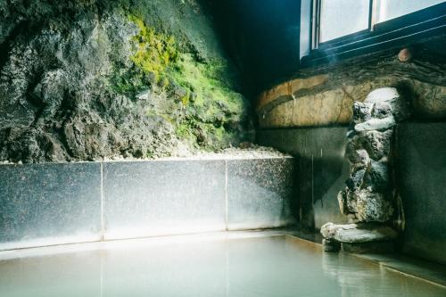 
a statue of a dog in a bathtub next to a window at Onsen Guesthouse HAKONE TENT in Hakone
