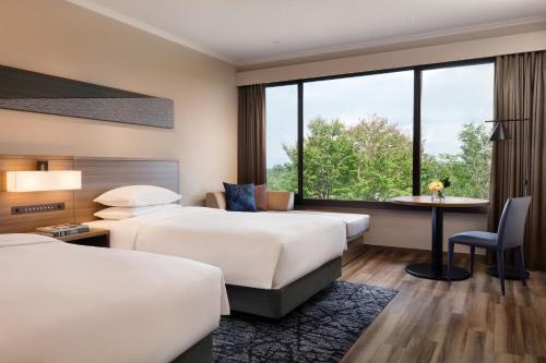 a hotel room with two beds and a desk at Izu Marriott Hotel Shuzenji in Izu