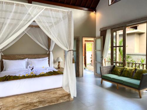 um quarto com uma cama de dossel e uma cadeira em Alamdhari Resort and Spa em Sidemen