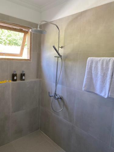 a shower stall in a bathroom with a towel at Alamdhari Resort and Spa in Sidemen