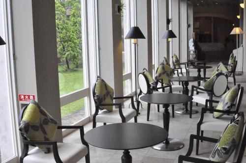 a row of tables and chairs in a room with windows at Hotel Nikko Huis Ten Bosch in Sasebo