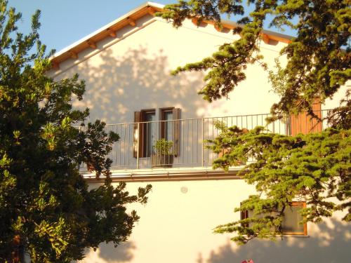 a balcony on the side of a building with trees at Agriturismo Ponterosa in Morrovalle