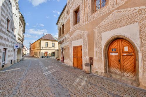 eine leere Straße mit zwei Holztüren an einem Gebäude in der Unterkunft Rodinný hostel Stárkův dům in Tábor