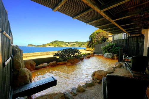 una piscina de agua con rocas en un edificio en IKI RETREAT by Onko Chishin, en Iki