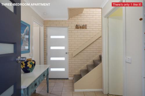 a hallway with a door leading to a kitchen at Panoramic Townhouses by Lisa in Merimbula