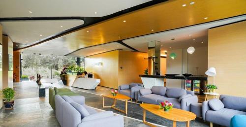 a living room with couches and tables in a building at TSR Seafront Hotel in Port Dickson