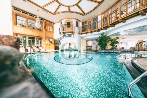 a swimming pool in a hotel with a large building at Wellnesshotel Warther Hof in Warth am Arlberg