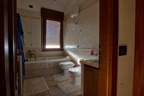 a bathroom with a toilet and a tub and a sink at ACQUARIO DEI FRALLE in Oristano