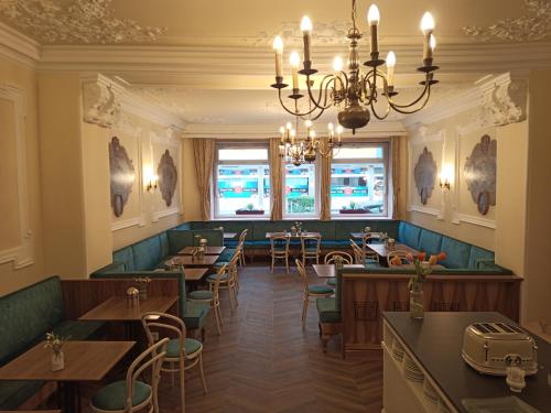 a restaurant with tables and chairs and a chandelier at Adlerhof in Salzburg