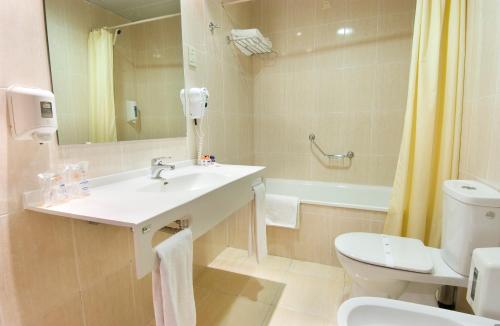 uma casa de banho com um lavatório, um WC e uma banheira em Eurosol Gouveia em Gouveia