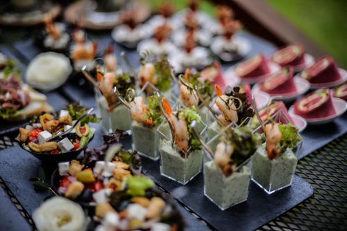 a bunch of food on a table with plates of food at Sodyba Duburiai in Ukmergė