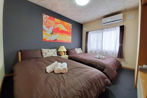 two beds sitting next to each other in a bedroom at 旭川ファミリーハウスみんみん in Asahikawa