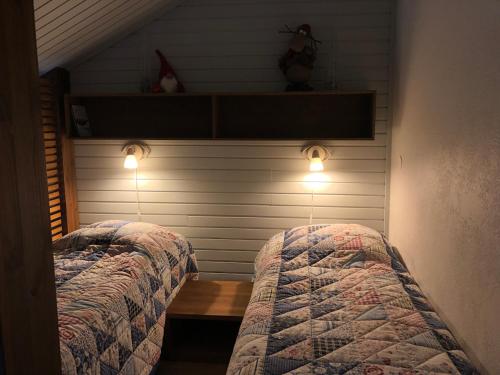 a bedroom with two beds and lights on the wall at Saaritupa Apartment Saariselkä in Saariselka