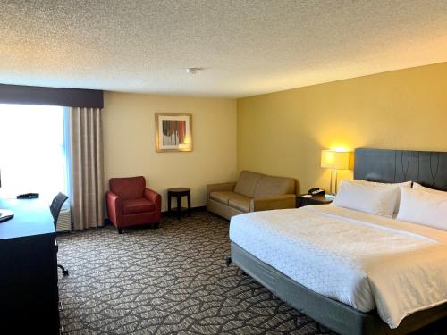 ein Hotelzimmer mit einem Bett und einem Stuhl in der Unterkunft Holiday Inn Express Tallahassee, an IHG Hotel in Tallahassee