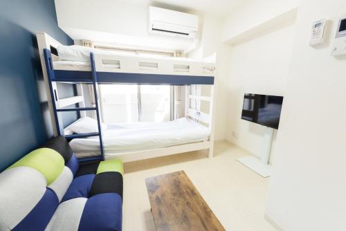 een kleine kamer met stapelbedden en een televisie bij Cocostay KO Residence Sennichimae3Fココステイ ケーオーレジデンス センニチマエ3F in Okayama