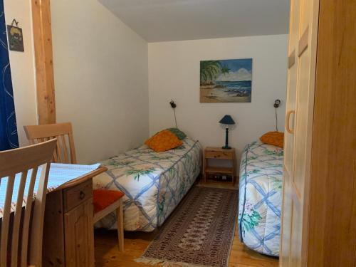 um quarto com 2 camas, uma mesa e uma secretária em Almagården lantlig miljö em Svängsta
