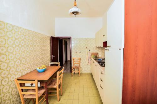 eine Küche mit einem Holztisch und einem Kühlschrank in der Unterkunft SoleMarePonza casa Antonietta in Ponza