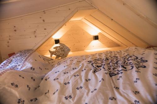 a bed in a room with a roof at Tiny-Haus im Südhessischen Ried in Trebur