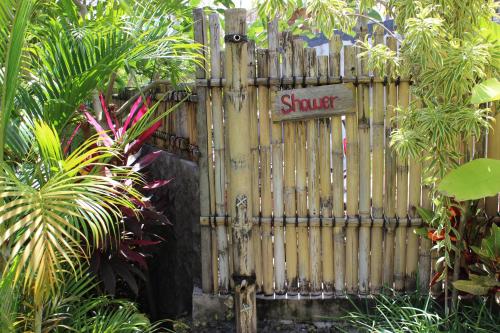 a wooden gate with a sign that reads sucker at The Calmtree Bungalows in Canggu