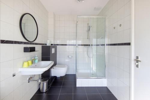 La salle de bains est pourvue d'un lavabo et d'une douche. dans l'établissement Seapoint - Sea view, à Zandvoort