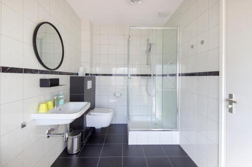 a bathroom with a toilet sink and a shower at Seapoint - Sea view in Zandvoort