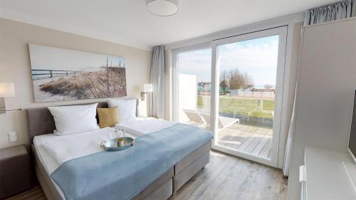 een slaapkamer met een bed en een groot raam bij Beach'n'Sea Wohnung 6 in Grömitz