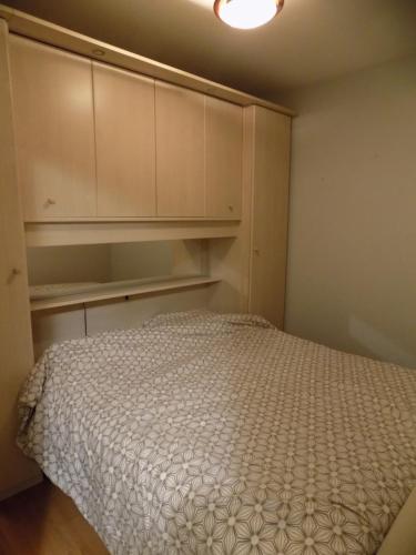 a small bedroom with a bed and cabinets at romanza 104 in Middelkerke