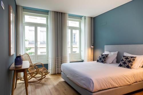 a bedroom with a large bed and two windows at VIVA Size Flats Clérigos in Porto
