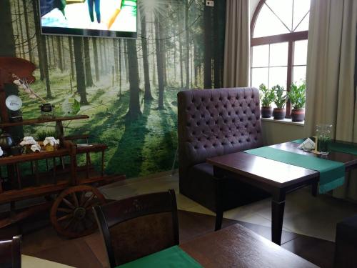 a living room with a couch and a tv in a forest at Malutkie Resort in Radomsko