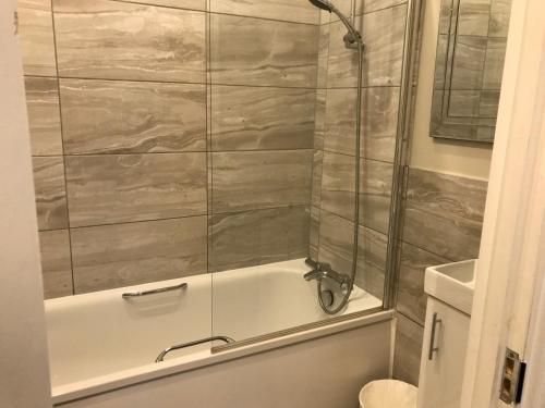 a bathroom with a tub and a toilet and a shower at Ravna Gora in London