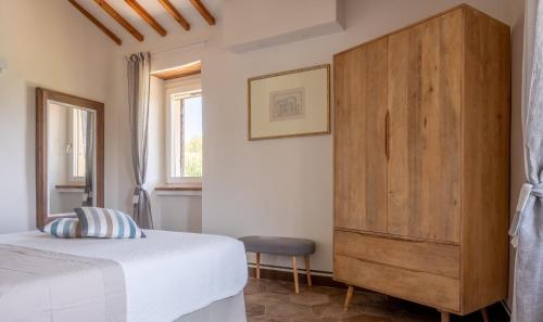 sypialnia z drewnianą komodą i łóżkiem w obiekcie Relais Il Furioso w mieście Monte Castello di Vibio