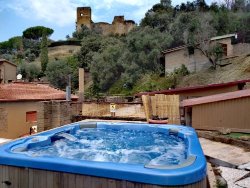 a hot tub on a roof with a castle in the background at ROMANTICA TOSCANA in Scarlino