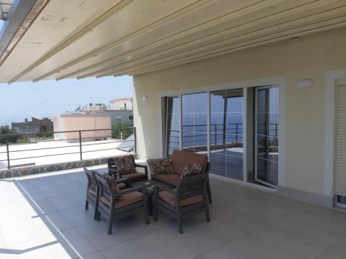 un patio con 2 sedie e un tavolo sul balcone di Kotarja Apartments a Dhërmi