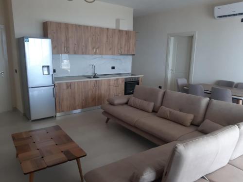 a living room with a couch and a kitchen at Kotarja Apartments in Dhërmi
