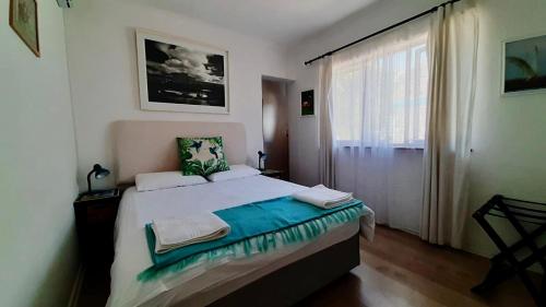 Un dormitorio con una cama grande y una ventana en The Speckled Egg, 4 Promenade Rd, Lakeside, Cape Town, en Ciudad del Cabo