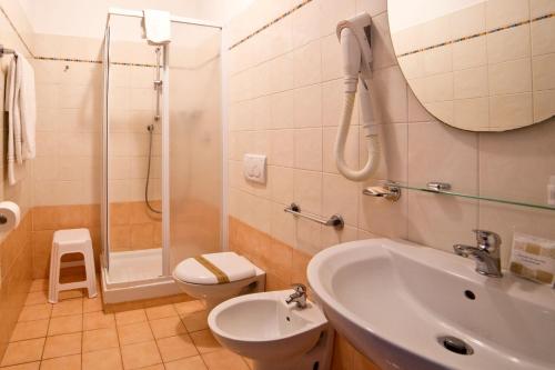 uma casa de banho com um lavatório, um chuveiro e um WC. em Hotel Kristall em Diano Marina