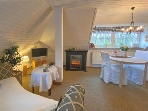 a living room with a table and a fireplace at Ferienhaus mit Garten in Weißenbrunn in Weißenbrunn