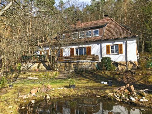 a house with a pond in front of it at Ferienhaus mit Garten in Weißenbrunn in Weißenbrunn