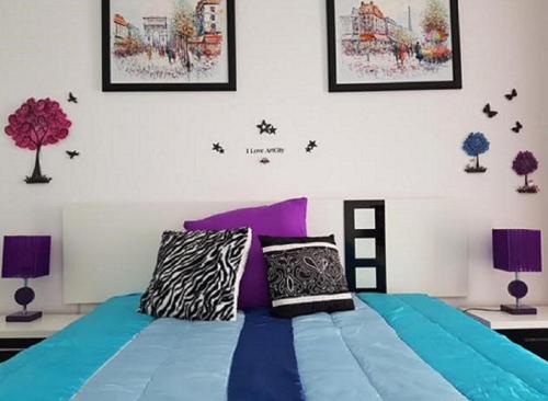 プラヤ・デ・ラス・アメリカスにあるAmericas Blue YoSeaのベッドルーム(紫色の枕が付いた青いベッド付)