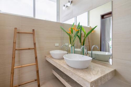 a bathroom with two sinks and two mirrors at Villa Claire - Seaview Private Villa in Bophut